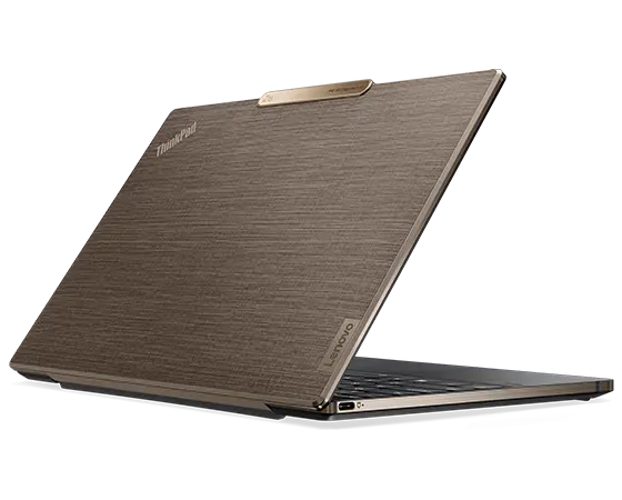 Lenovo ThinkPad Z13 Gen 2 Notebook mit bronzefarbenem Aluminiumgehäuse sowie Flachsfaser auf dem Displaydeckel, Schrägansicht von hinten mit Blick auf die linkseitigen Anschlüsse und Steckplätze.