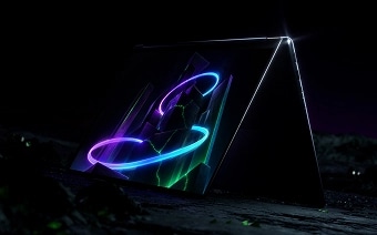 A right-front view of a Lenovo Yoga laptop in tent mode, showing green, blue, and purple graphics on the display.