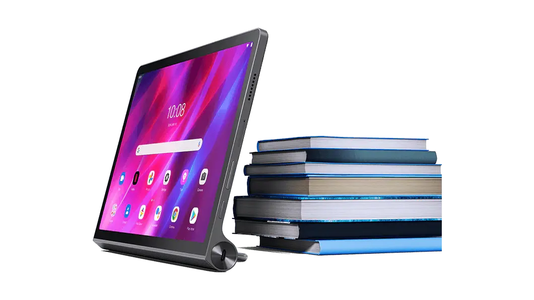 Tablet Lenovo Yoga Tab 11: vista frontal derecha ¾, colocada frente a una pila de libros, con la pantalla de inicio y los íconos de aplicaciones en la pantalla