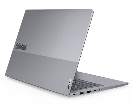 Rear, left side view of Lenovo ThinkBook 14 Gen 7 (14'' Intel) laptop opened at an acute angle, focusing its top cover highlighting the ThinkBook logo & its five visible ports.