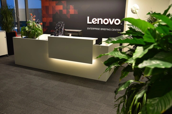 A large reception desk with a Lenovo sign behind it