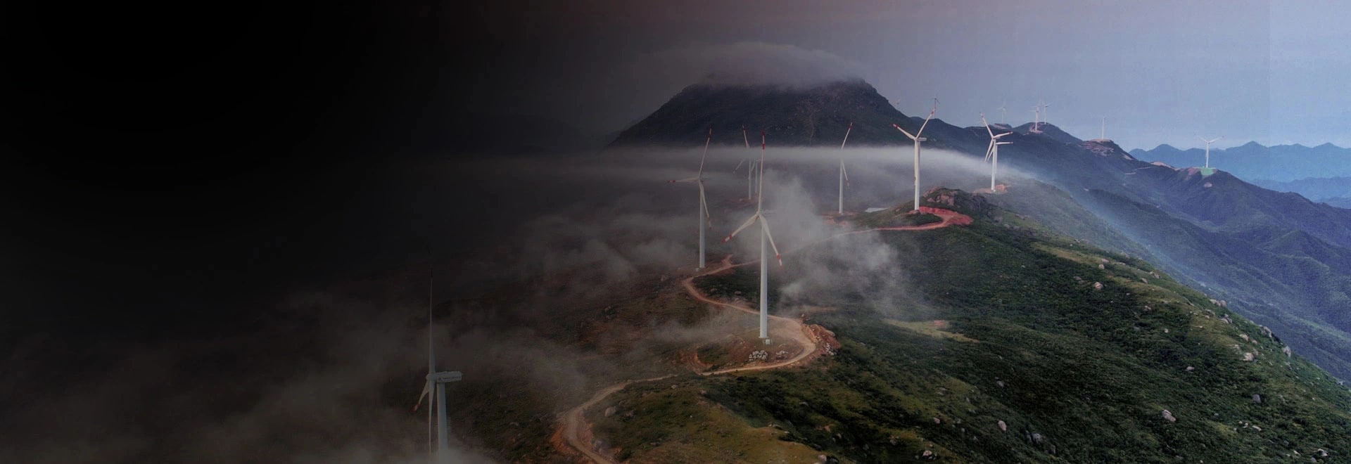 A number of wind turbines on top of a mountain range