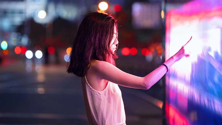 Une femme touchant une carte interactive dans une rue