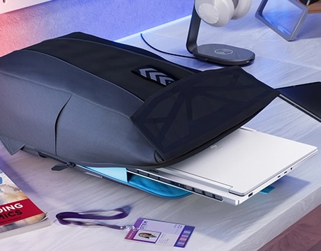 Legion 7i Gen 10 partially tucked into a backpack on a desk next to school supplies.