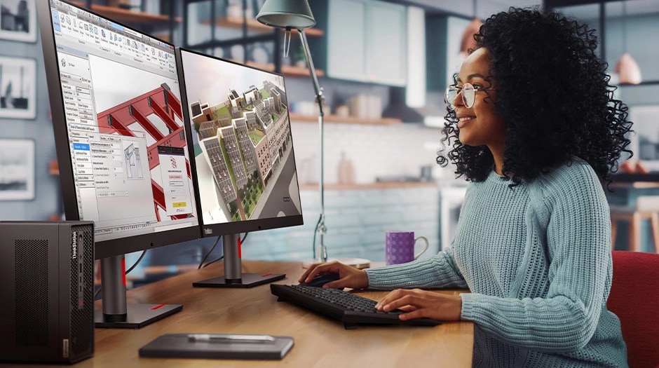 A person using a Lenovo ThinkStation P3 Ultra SFF Gen 2 workstation at a desk to examine 3D models on two monitors