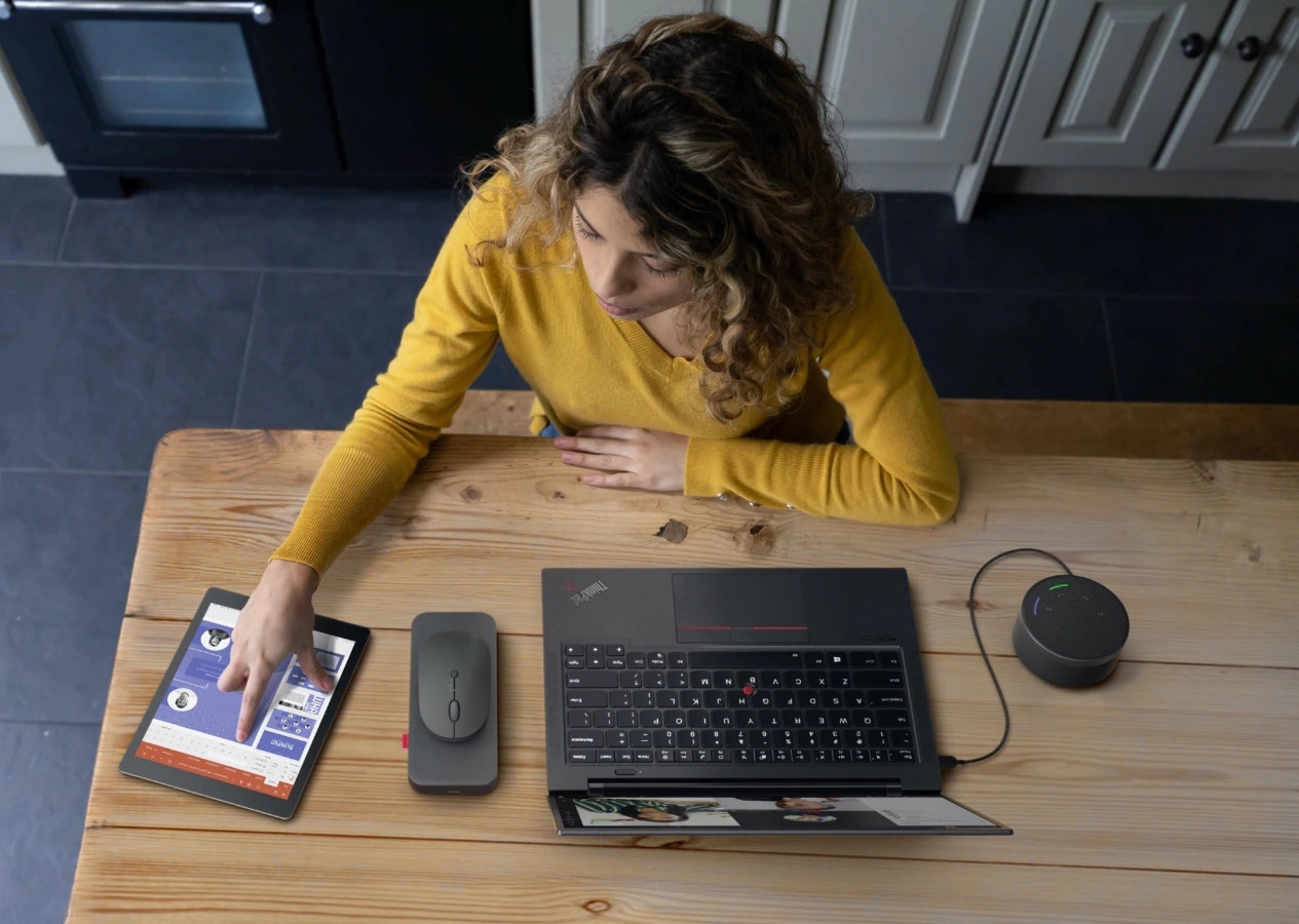 Woman using Lenovo Go accessories at kitchen table