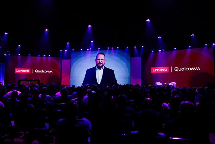 O CEO da Qualcomm, Cristiano Amon, fazendo uma apresentação virtual na tela com as marcas Lenovo e Qualcomm.