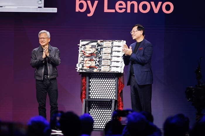 O CEO da Lenovo, Yuanqing Yang, e o CEO da NVIDIA, Jensen Huang, apresentando um hardware no palco, exibindo a tecnologia com marca Lenovo.