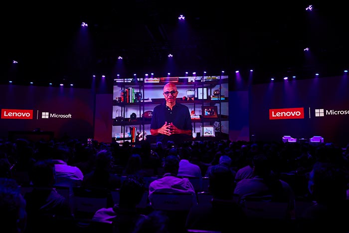 Uma apresentação virtual com o CEO da Microsoft, Satya Nadella, em uma grande tela em um evento co-organizado pela Lenovo e Microsoft.