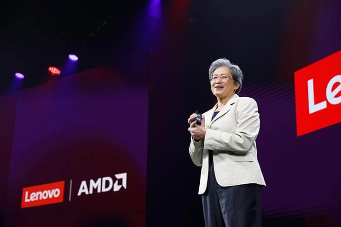 A CEO da AMD, Dra. Lisa Su, de pé no palco, apresentando com os logotipos da Lenovo e AMD ao fundo.