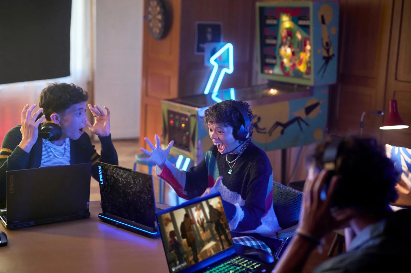 A group of excieted gamer celebrating a win while playing on Lenovo Legion laptops.