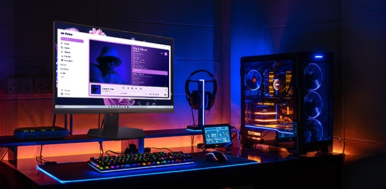 A fully equipped gaming room with a Legion-10 monitor, desktop, and peripherals. The monitor is playing music.