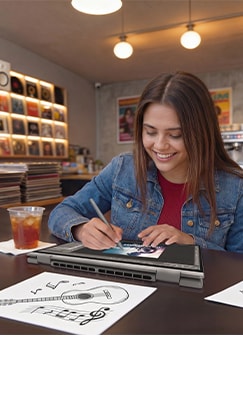 A female student smiles while drawing on a Lenovo IdeaPad with a stylus at her desk.