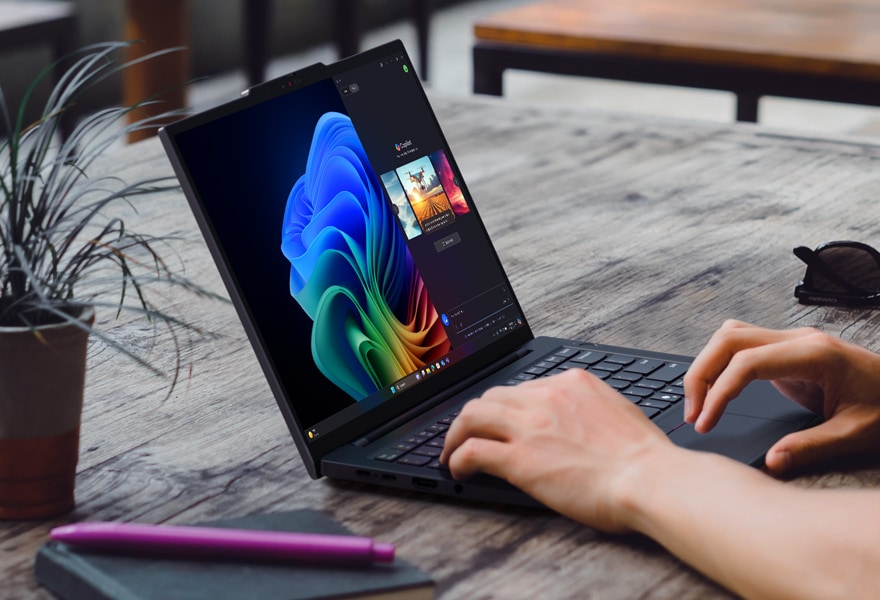 Lenovo ThinkPad X1 Yoga Gen 8 2-in-1 laptop in tent mode next to a wireless keyboard, being used with the integrated pen.