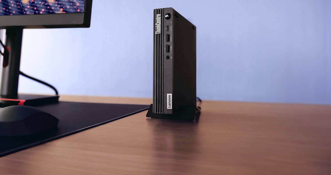 Un ordinateur de bureau ThinkCentre de tout petit format placé à côté d’un moniteur et d’un clavier.