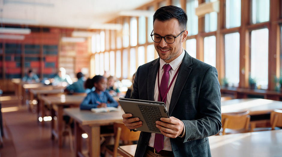 A professional in a library holds a Lenovo ThinkBook 14 2-in-1 Gen 6 laptop in Tablet mode, positioned vertically.
