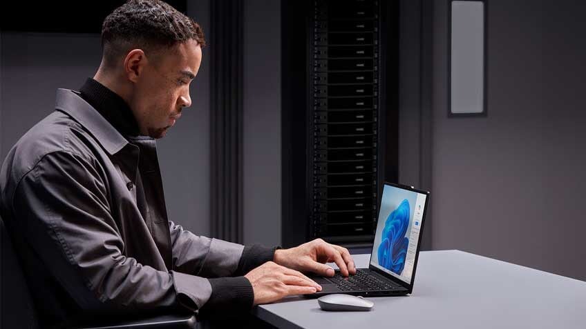 A man sitting at a desk working on a laptop  