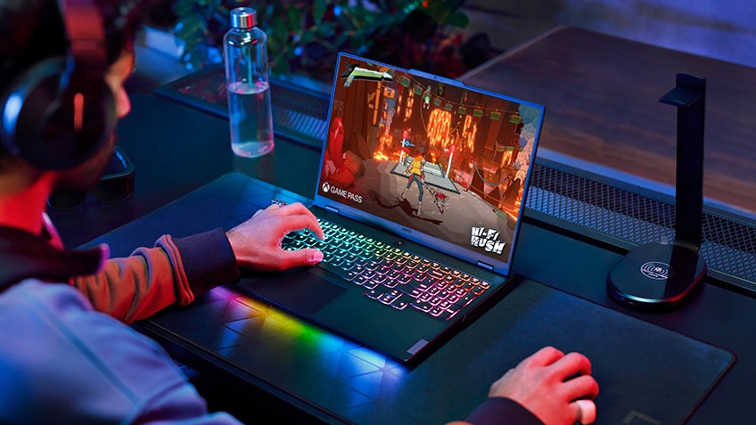 Three boys engaged in gaming on their laptops and wearing headphones 