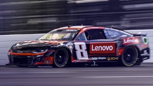 Shot of a speeding black NASCAR race car sponsored by Lenovo.