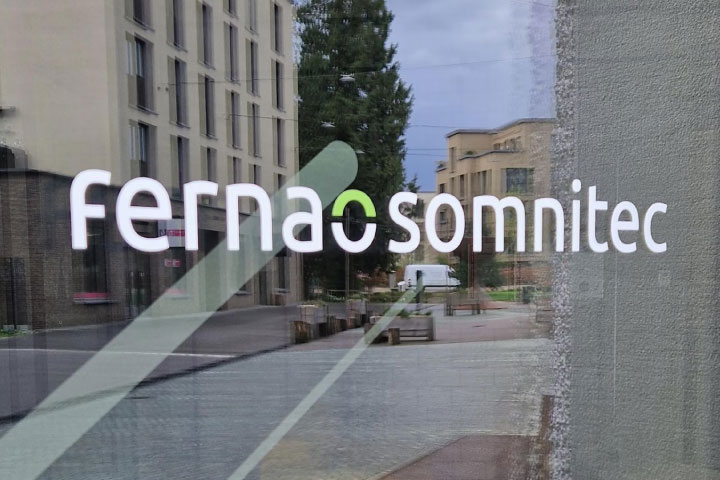 The image shows people in an office examining data on monitors. 