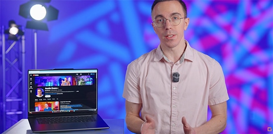 Austin Evans next to a Yoga Pro 9i Gen 11 Aura Edition (16” Intel) laptop.
