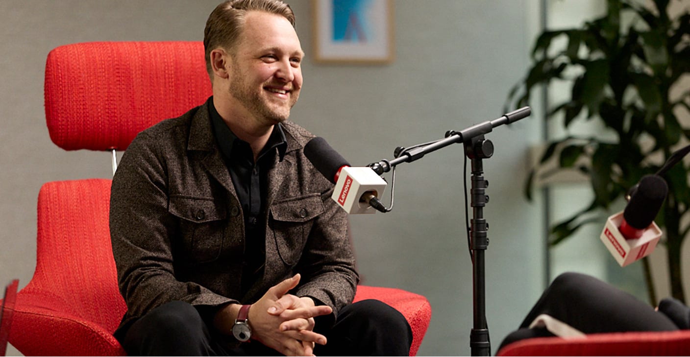 Robert Daigle in a red chair talking into a microphone.