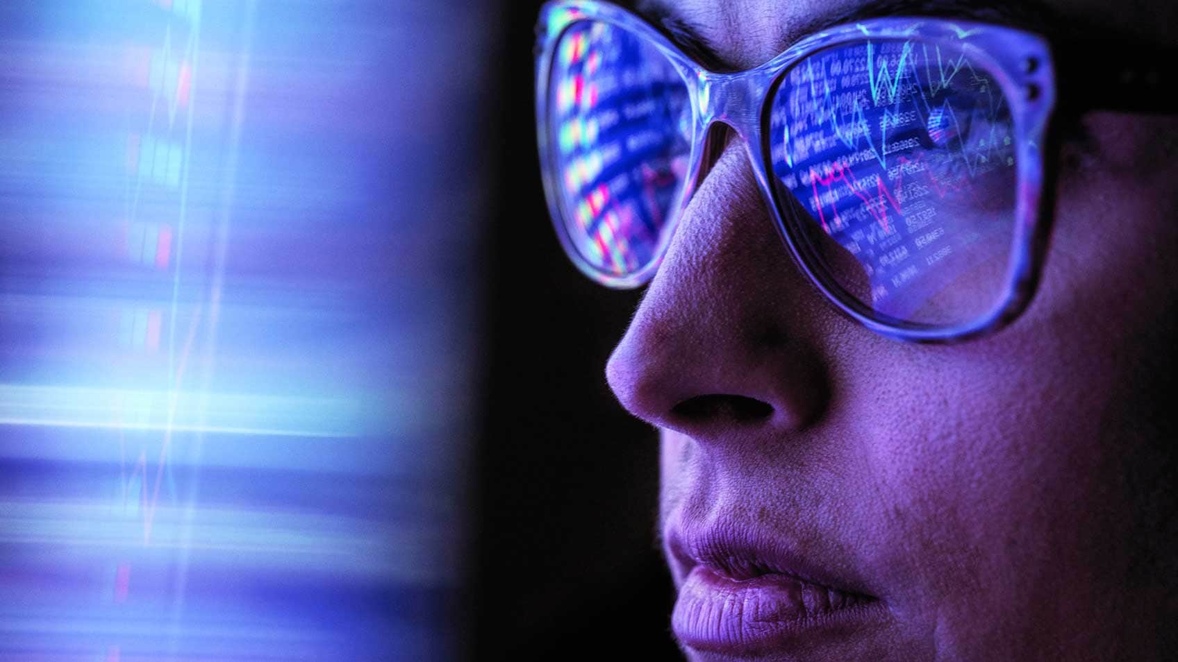 Femme regardant un écran avec les données qui en ressortent dans ses lunettes.