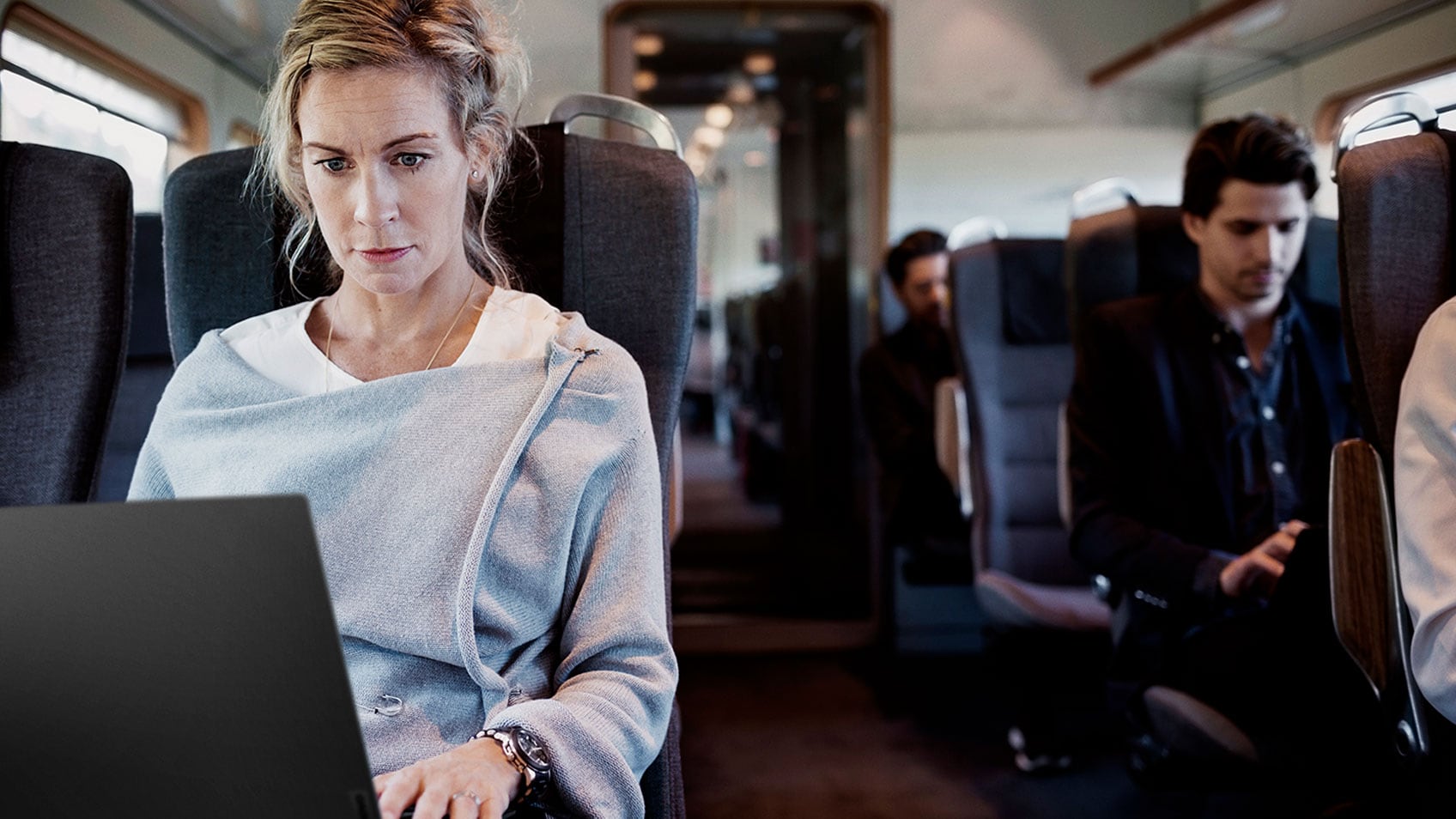 A woman on a train working on her laptop