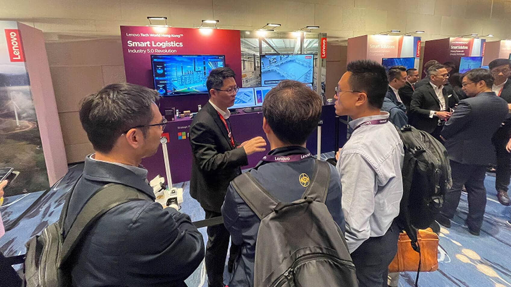 A Lenovo employee at the Lenovo booth talking to Tech World attendees.