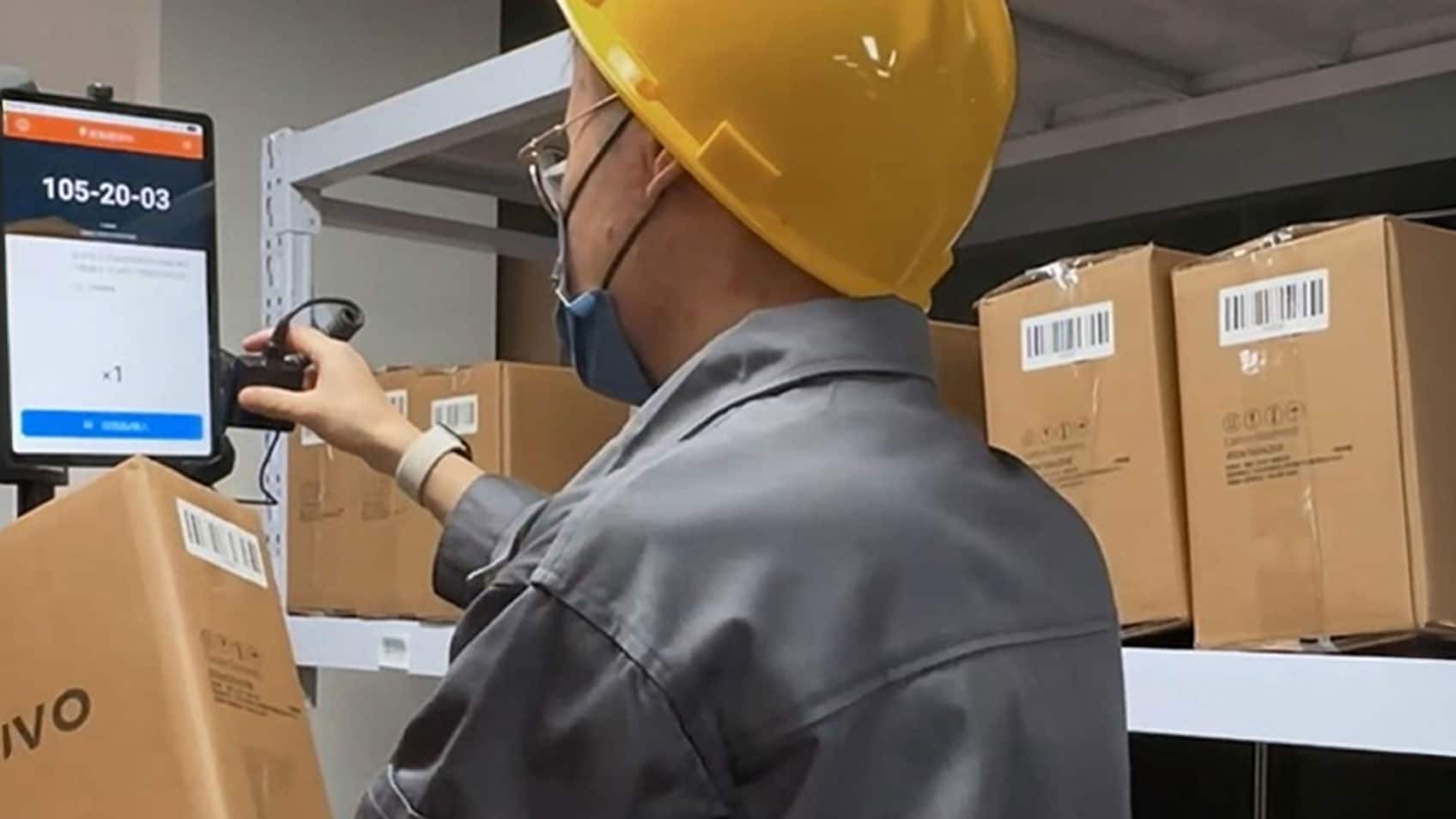 A worker scanning a Lenovo box before shipping it out. 