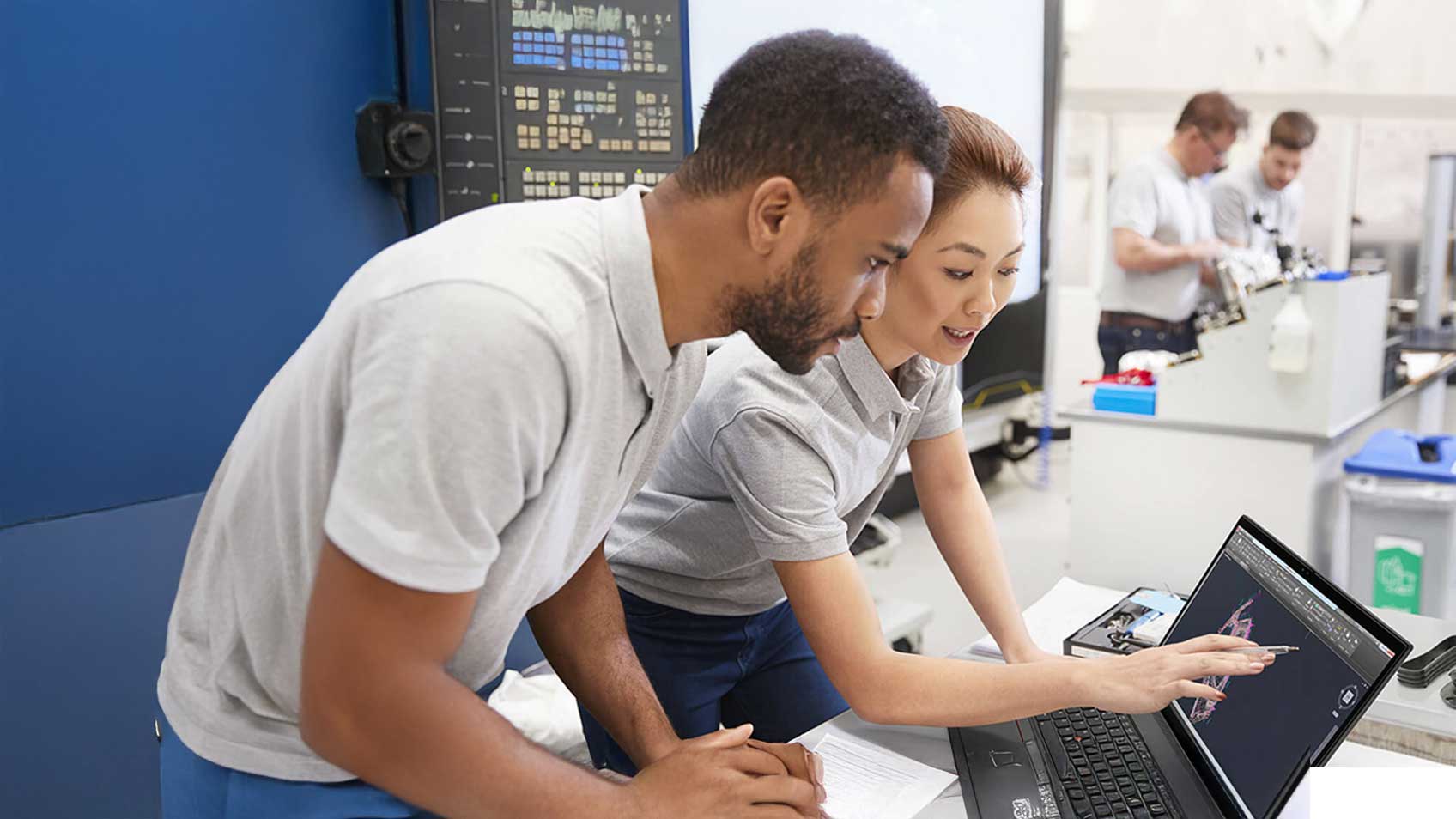 Des collègues travaillent ensemble sur un portable.