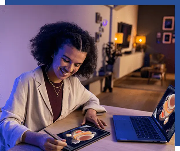 A woman in a home setting, stylus in hand, examines images of the moons of Jupiter on a Lenovo tablet and on a Lenovo laptop