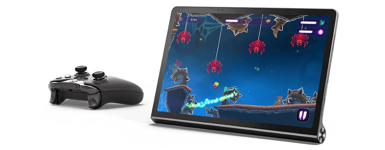 Vue avant de la tablette Lenovo Yoga Tab 11 avec un jeu d’aventure à l’écran et une manette de jeu sans fil à côté de la tablette