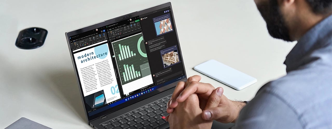 Un homme regarde le Lenovo ThinkPad X1 Nano dont l’écran, divisé en 3, présente un article, des graphiques et des images.