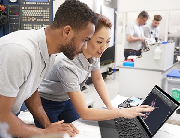 Two people standing at a desk in a data center, looking at an illustration on a ThinkPad P14s Gen 4 (14
