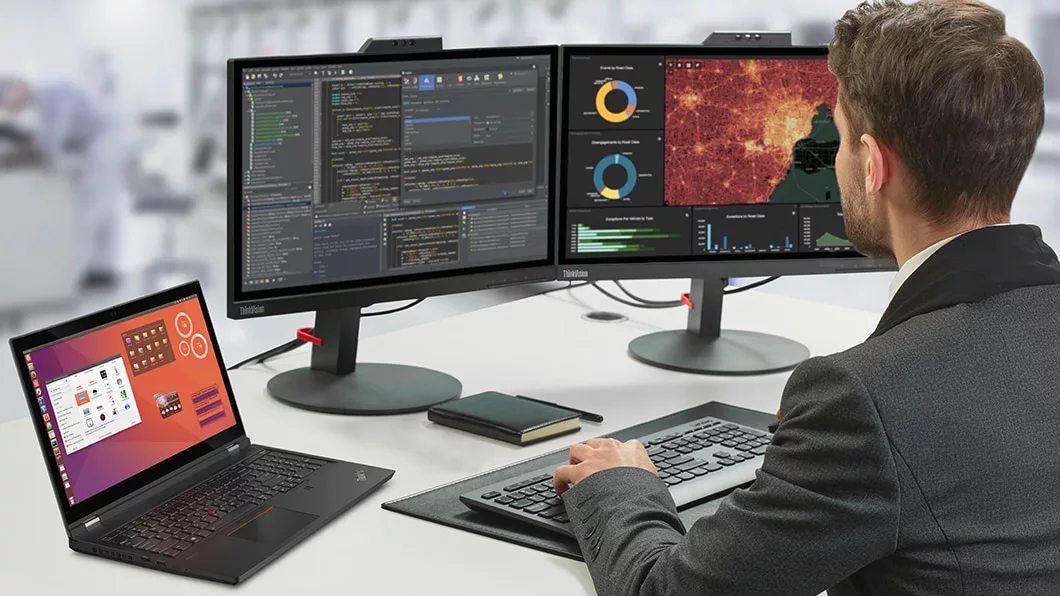 Man working with the ThinkPad T15g laptop attached to dual monitors